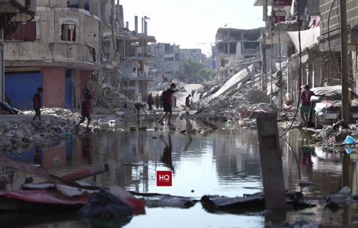 Thumbnail preview image for the video titled: Children try to cross street flooded by sewage due to Israel's destruction of infrastructure