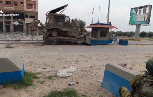 Thumbnail preview image for the video titled: An IDF bulldozer demolishes a booth, while a soldier laughs in the background