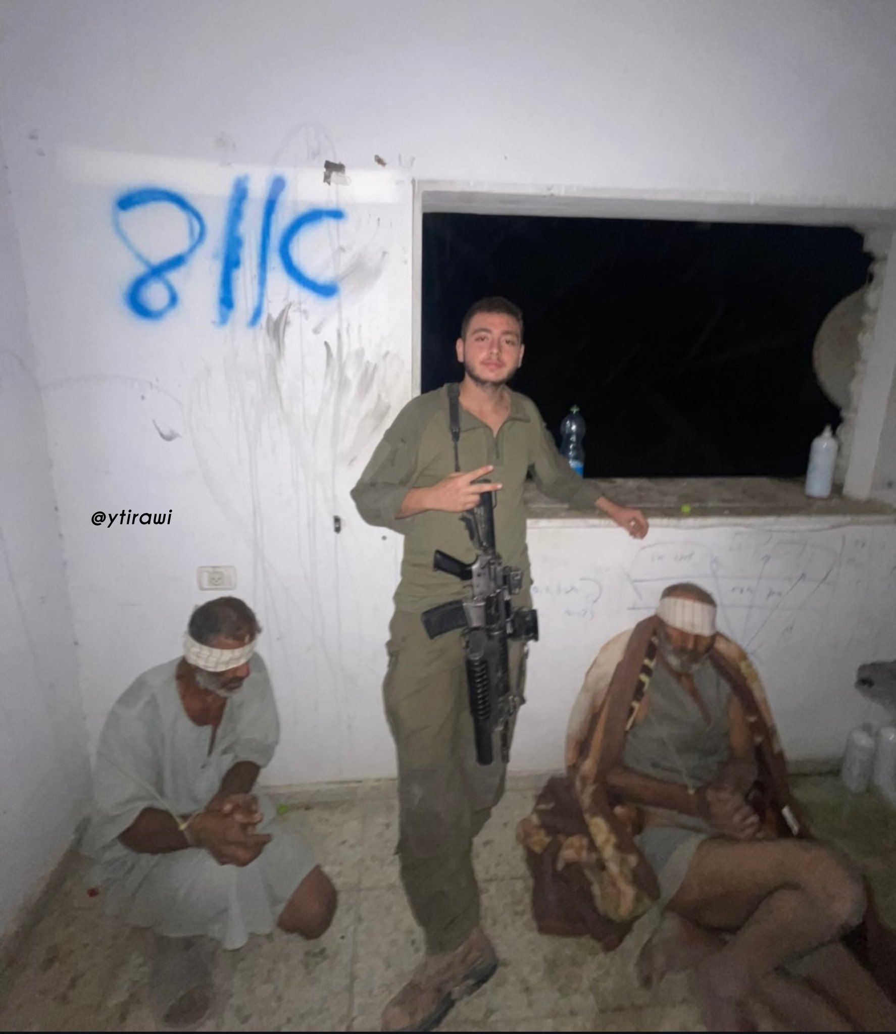 Thumbnail preview image for the video titled: IDF soldier poses with two blindfolded and stripped elderly men taken as human shields